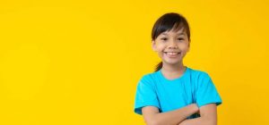 smiling-girl-yellow-background-1024x478