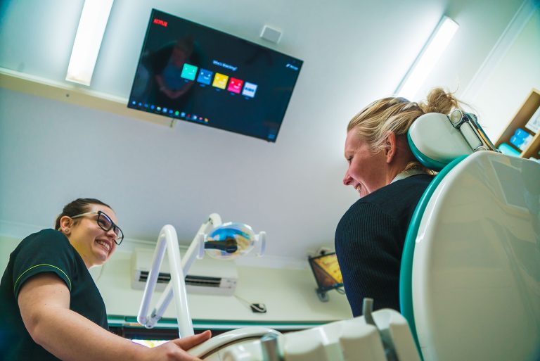 Dental team member with a smiling patient at Rockingham Dental Centre