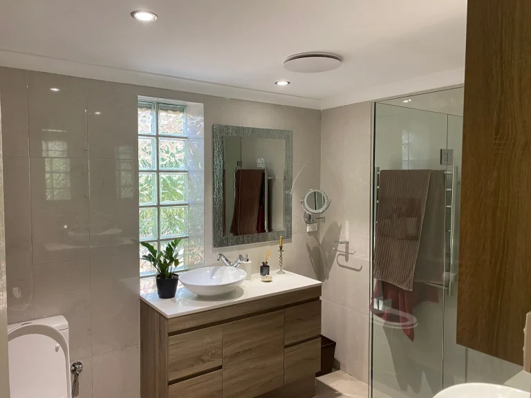 Renovated bathroom with a timber vanity and frameless shower in Perth