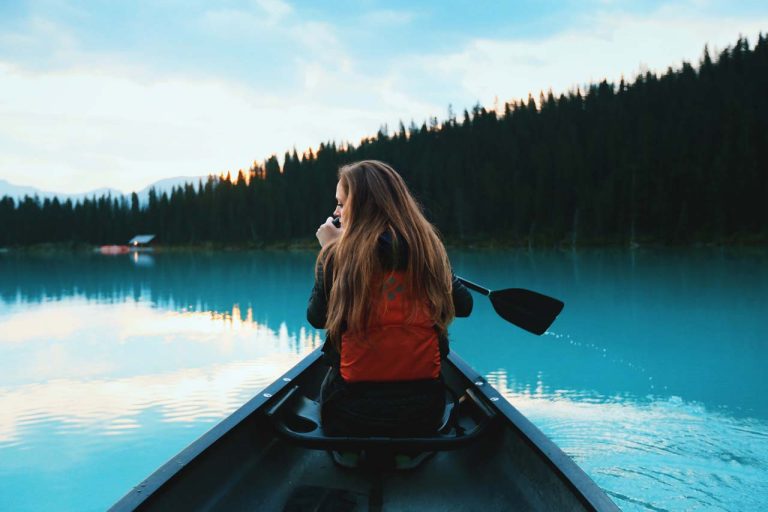 Woman paddling a canoe on calm water